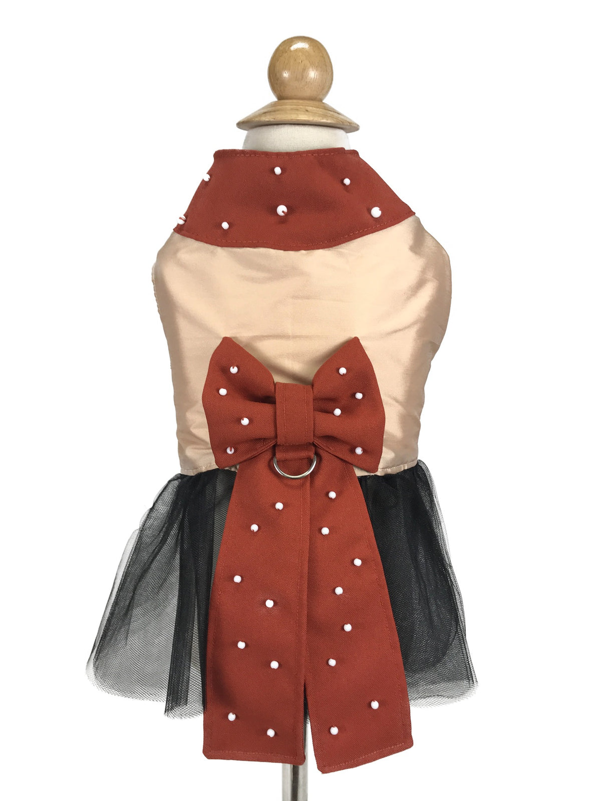 Mannequin back view showing rust-red statement bow and collar with white accents and black tulle dog dress skirt